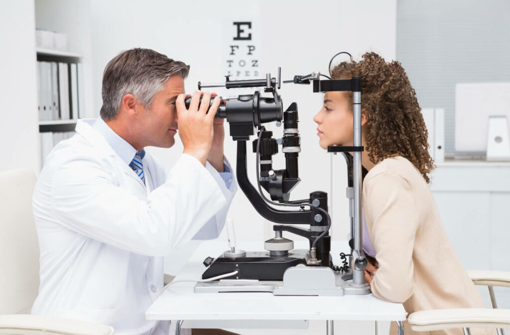 A young woman undergoing an eye exam administered by an eye doctor.