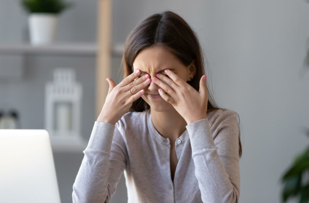 A woman aggressively rubbing her eyes.