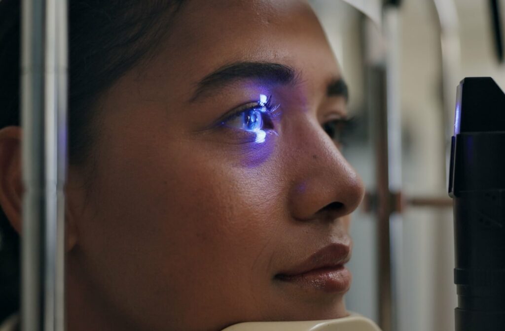 A female patient stares straight ahead during a slit lamp exam.