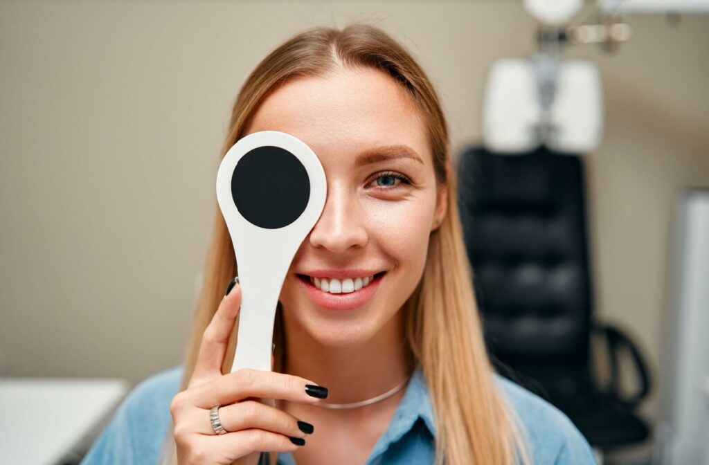 a woman has one of her eyes covered during her eye exam to get screened for other diseases.