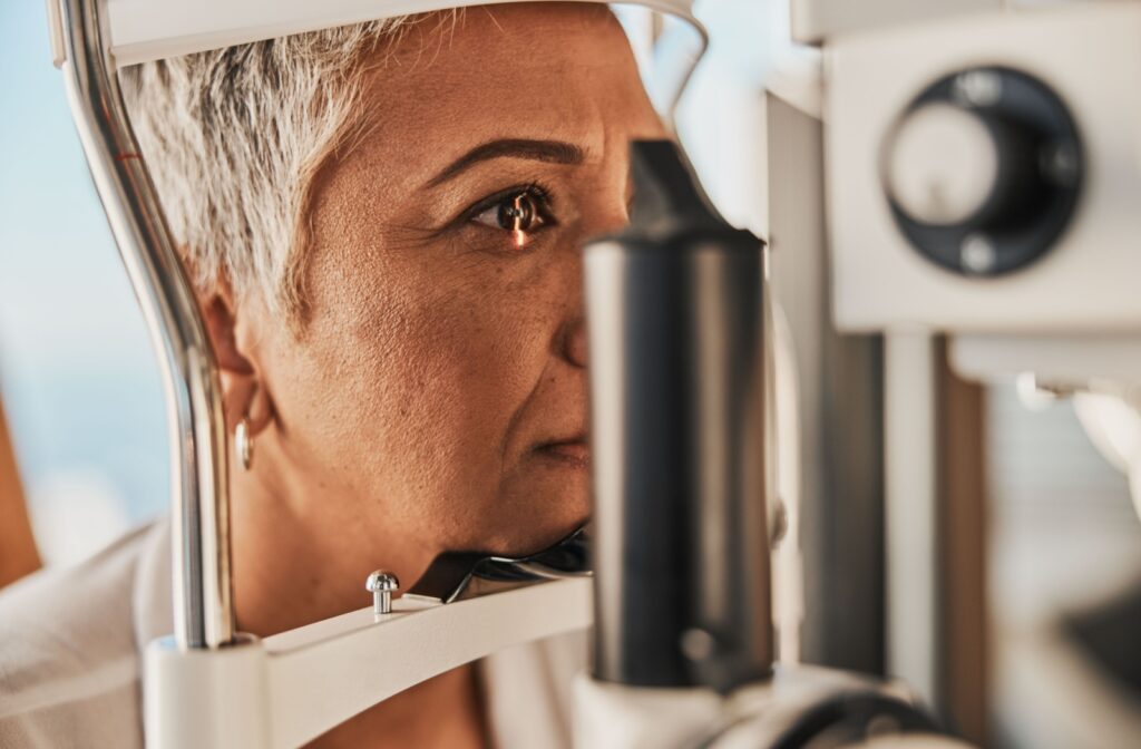 Senior woman in the foreground undergoing an eye exam emphasizing cataract diagnosis with advanced diagnostic equipment